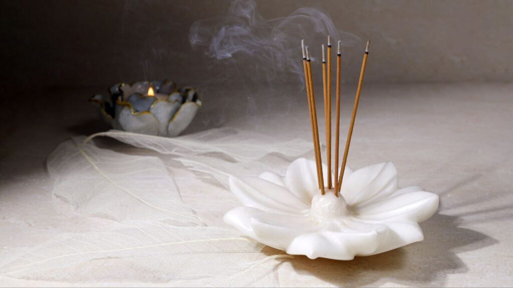 seis incensos queimando em suporte em formato de flor para limpeza espiritual